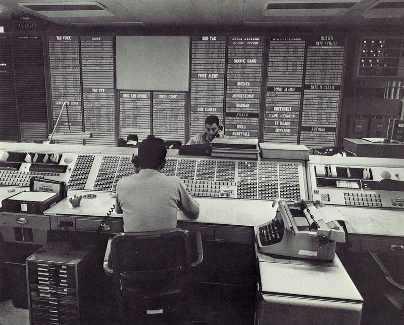 Original caption from 1970: PATHS OF A SATELLITE - Deep within Colorado’s Cheyenne Mountain are large display screens which show what is going on in space. These screens in the NORAD Combat Operations Center can show the routes space satellites will take as they circle the earth, such as the ones here charted by a computer. By pushing buttons the battle staff members can see the paths a satellite will follow for as many as twelve revolutions in the future. While guarding the continent against air attack, the command is also responsible for keeping tabs on space objects orbiting the earth. (Photo scanned by Memory Hole 2 from the book NORAD Command Post: The City Inside Cheyenne Mountain by Henry W. Hough)